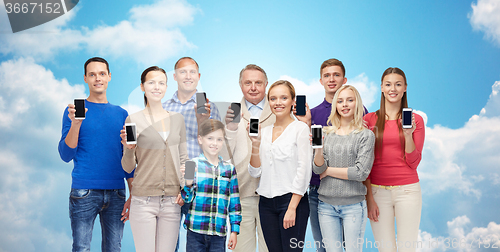 Image of happy people with smartphones over sky and clouds