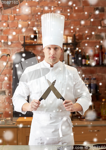 Image of happy male chef cook in kitchen with knife