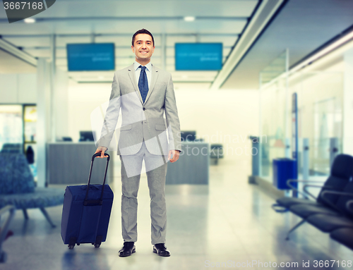 Image of happy businessman in suit with travel bag