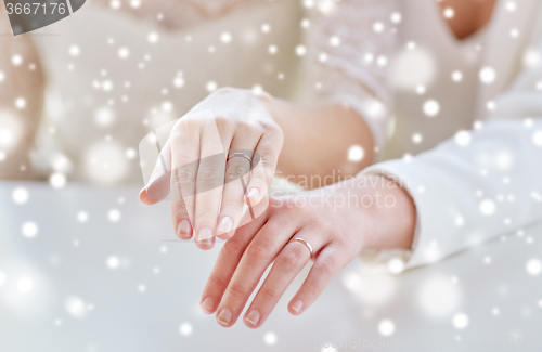 Image of close up of lesbian couple hands and wedding rings