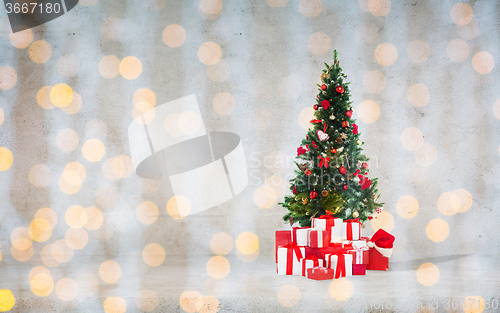 Image of christmas tree with gifts over concrete wall