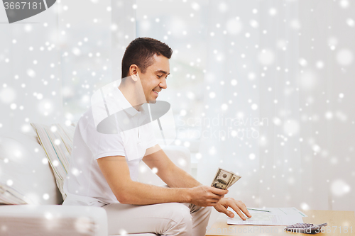 Image of man with papers and calculator counting money