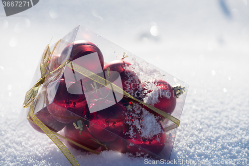 Image of christmas balls in box on fresh  snow