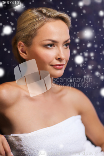 Image of beautiful woman sitting in bath towel at sauna