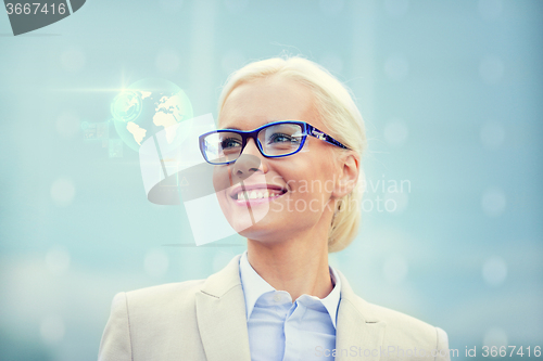 Image of young smiling businesswoman in eyeglasses outdoors