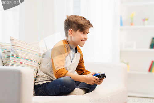 Image of happy boy with joystick playing video game at home