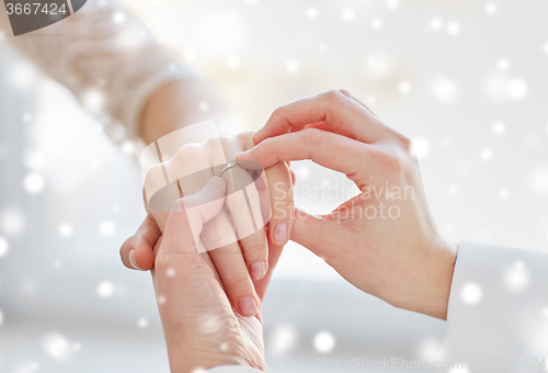 Image of close up of lesbian couple hands with wedding ring