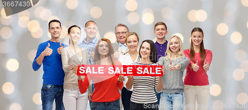 Image of happy people with red sale sign showing thumbs up