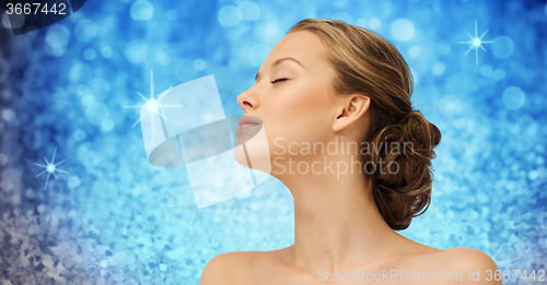 Image of young woman face and shoulders over blue lights