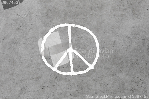 Image of peace sign drawing on gray concrete wall