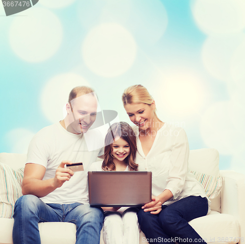 Image of happy family with laptop computer and credit card