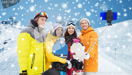 Image of happy friends with snowboards and smartphone