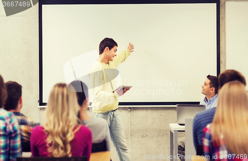 Image of group of smiling students and teacher in classroom