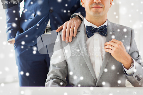 Image of close up of male gay couple with wedding rings on