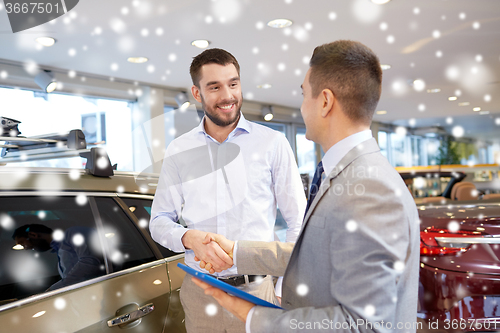 Image of happy man shaking hands in auto show or salon