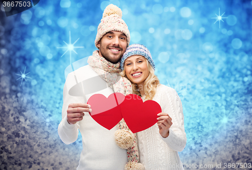 Image of smiling couple in winter clothes with red hearts