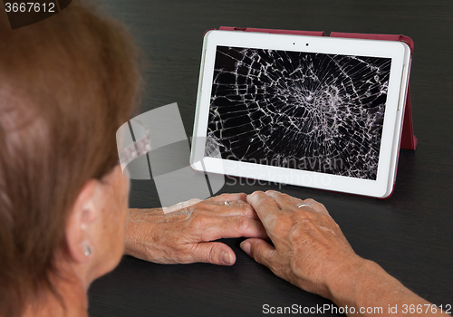 Image of Senior lady with tablet, cracked screen