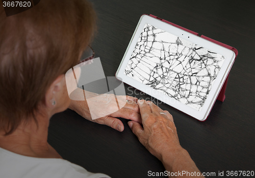 Image of Senior lady with tablet, cracked screen