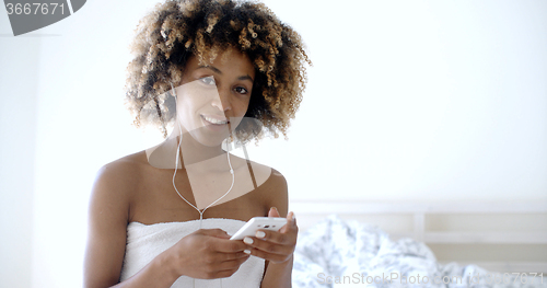 Image of Young Girl Wearing Bath Towel listening to music