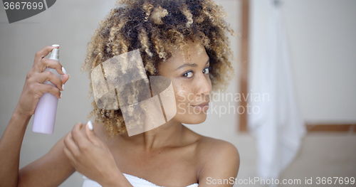 Image of Woman Using Hair Spray In Bathroom