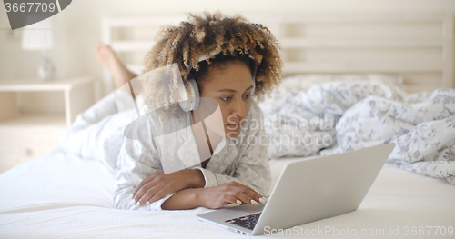 Image of Woman Using Her Laptop In Bed