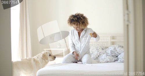 Image of Woman And Her Dog Resting In Bed
