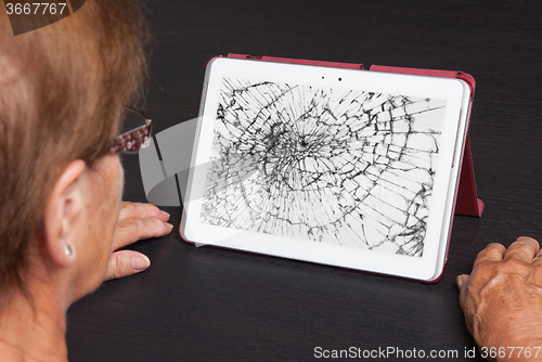 Image of Senior lady with tablet, cracked screen