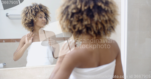 Image of Woman Arranging Her Exotic Curly Hair