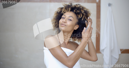 Image of Woman Using Hair Spray In Bathroom