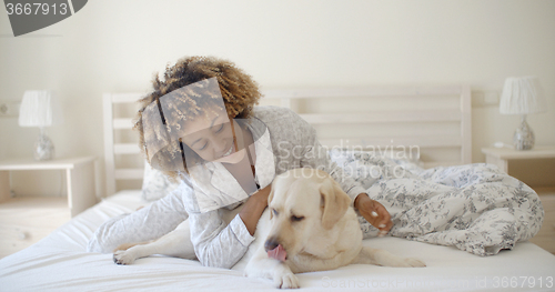 Image of Woman Is Holding A Dog On A Bed