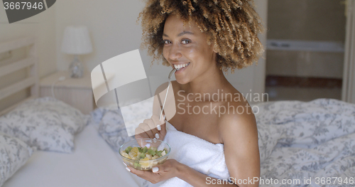 Image of Young Woman On Bed Eating Vegetable Salad
