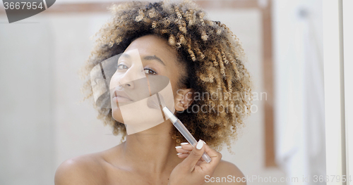 Image of Young Woman Putting Make Up