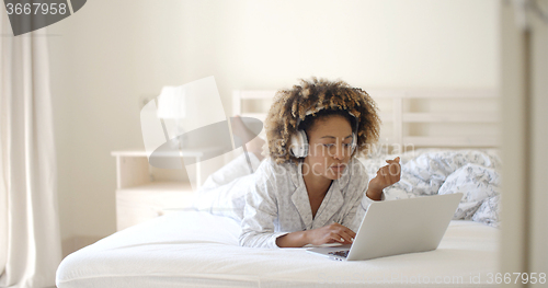 Image of Woman Using Her Laptop In Bed