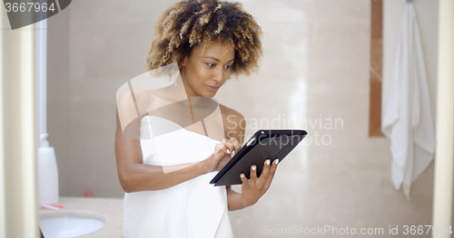 Image of Woman Using Tablet Computer In The Bath