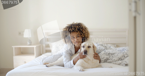 Image of Woman Is Holding A Dog On A Bed