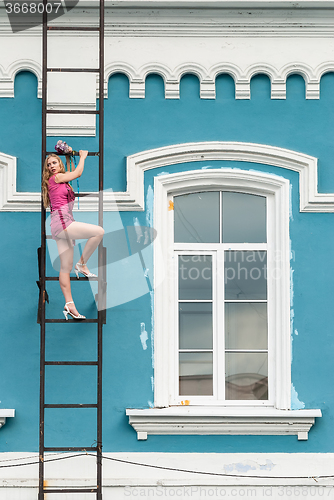 Image of Pretty woman in pink on fire escape stair