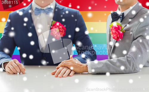 Image of close up of happy male gay couple holding hands