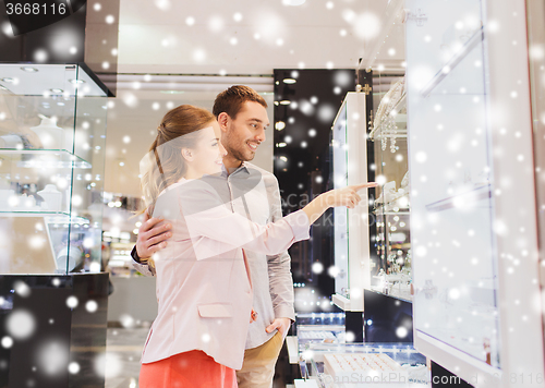 Image of couple looking to shopping window at jewelry store