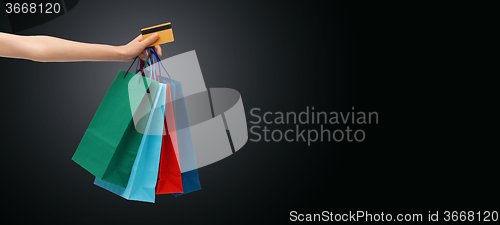 Image of close up of woman with shopping bags and bank card