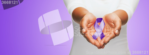 Image of close up of hands holding purple awareness ribbon