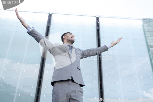 Image of young smiling businessman over office building