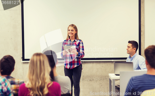 Image of group of smiling students and teacher in classroom