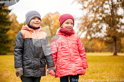 Image of happy little girl and boy in autumn park