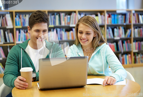 Image of happy students with laptop in library