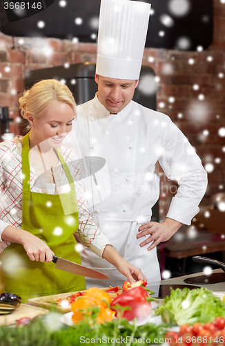 Image of happy male chef cook with woman cooking in kitchen