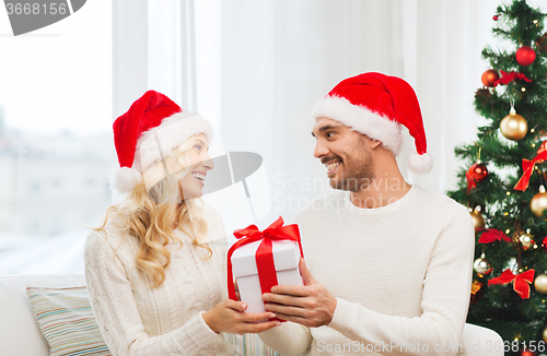 Image of happy couple at home with christmas gift box