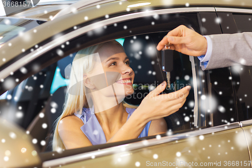 Image of happy woman getting car key in auto show or salon