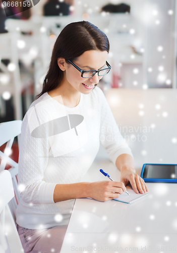 Image of smiling woman with tablet pc at cafe