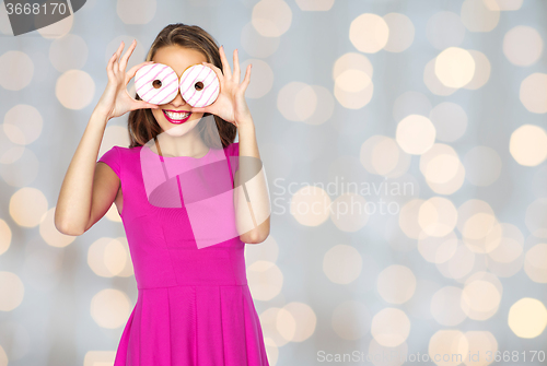 Image of happy woman or teen girl looking through donuts