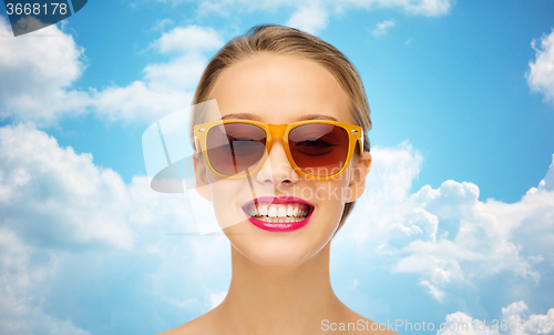 Image of happy young woman in sunglasses with pink lipstick